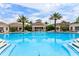 Resort-style community pool with palm trees, lounge chairs, and a central pavilion at 2301 Butterfly Palm Way # 303, Kissimmee, FL 34747