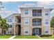 Inviting condominium featuring a charming exterior, balconies, and well-maintained landscaping at 2301 Butterfly Palm Way # 303, Kissimmee, FL 34747