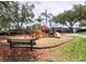 A vibrant community playground with slides and play structures, surrounded by mature trees at 2301 Butterfly Palm Way # 303, Kissimmee, FL 34747