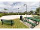 Outdoor volleyball court with sand, benches, and picnic tables in a sunny community setting at 2301 Butterfly Palm Way # 303, Kissimmee, FL 34747