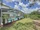 Inviting backyard featuring a screened-in pool, lush landscaping, and ample space for outdoor relaxation at 2408 Saint Augustine Blvd, Haines City, FL 33844