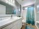 Well-lit bathroom featuring a stylish vanity, shower with curtain, and tiled flooring, offering a practical and clean space at 2408 Saint Augustine Blvd, Haines City, FL 33844