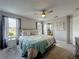 Relaxing bedroom showcasing a comfortable bed, ceiling fan, and an adjacent bathroom for added convenience at 2408 Saint Augustine Blvd, Haines City, FL 33844