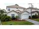 Inviting two-story home with a well-manicured lawn, attached two-car garage and beautiful front yard landscaping at 2408 Saint Augustine Blvd, Haines City, FL 33844