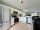 Spacious kitchen with white cabinets, stainless steel appliances, and an open view into the living room at 2408 Saint Augustine Blvd, Haines City, FL 33844