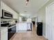 Open kitchen featuring white cabinets, stainless steel appliances, and seamless flow into the living area at 2408 Saint Augustine Blvd, Haines City, FL 33844