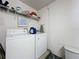 Functional laundry area with washer, dryer, and shelving for storage, offering convenience at 2408 Saint Augustine Blvd, Haines City, FL 33844