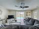 Comfortable living room with a plush sofa, ceiling fan, and sliding glass doors with a pool view at 2408 Saint Augustine Blvd, Haines City, FL 33844
