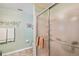 Bathroom with frosted shower door, soft green walls, and neutral tile floors at 247 Bell Tower Xing W, Poinciana, FL 34759