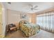 Inviting bedroom with floral bedding, chair, and large window with sheers for natural light, and ensuite bathroom at 247 Bell Tower Xing W, Poinciana, FL 34759
