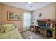 Serene bedroom with neutral walls, a desk area, and soft, natural light at 247 Bell Tower Xing W, Poinciana, FL 34759