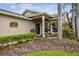 Charming front porch area with lush landscaping and cozy seating at 247 Bell Tower Xing W, Poinciana, FL 34759