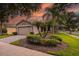 Charming single-story home featuring a well-manicured lawn and tropical landscaping at 247 Bell Tower Xing W, Poinciana, FL 34759