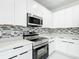 Modern kitchen featuring stainless steel appliances and white cabinetry at 2639 Sw 162Nd Street Rd, Ocala, FL 34473