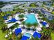 Aerial view of resort pool, club house, palm trees, and pool lounge area surrounded by neighborhood homes at 2649 Calistoga Ave, Kissimmee, FL 34741