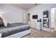 Modern bedroom featuring a plush bed, dresser with TV, and large mirror reflecting into the en-suite bathroom at 2649 Calistoga Ave, Kissimmee, FL 34741