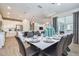 Open concept dining area with a table set for eight, plus modern chandelier, and sight lines to the kitchen and Gathering room at 2649 Calistoga Ave, Kissimmee, FL 34741