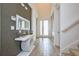 Stylish entryway with patterned accent wall, sleek console table, and modern decor, plus light wood-look tile flooring at 2649 Calistoga Ave, Kissimmee, FL 34741