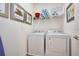 Bright laundry room featuring a white washer, dryer, and decorative wall art at 2649 Calistoga Ave, Kissimmee, FL 34741