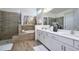 Luxurious main bathroom featuring a double vanity, soaking tub, walk-in shower, and stylish tile at 2649 Calistoga Ave, Kissimmee, FL 34741
