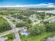Aerial view of a charming neighborhood with lush greenery, trees, and a blue-roofed home at 302 E Drury Ave, Kissimmee, FL 34744