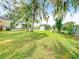 Expansive backyard with mature trees and a serene pond featuring a fountain at 302 E Drury Ave, Kissimmee, FL 34744