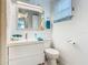 Bright bathroom with seashell mirror and accent, complemented by white fixtures and design at 302 E Drury Ave, Kissimmee, FL 34744