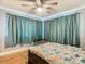 Cozy bedroom with a ceiling fan and large windows, showcasing natural light and wood floors at 302 E Drury Ave, Kissimmee, FL 34744