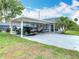 Carport with parking for multiple vehicles, and a well-maintained front lawn at 302 E Drury Ave, Kissimmee, FL 34744