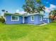 Charming exterior view of a light blue house featuring a well-manicured lawn and bright natural light at 302 E Drury Ave, Kissimmee, FL 34744