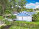 Exterior showcasing the blue siding, white trim, and well-maintained landscaping at 302 E Drury Ave, Kissimmee, FL 34744