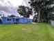 Charming blue single-story home featuring a well-maintained lawn and beautiful, mature trees at 302 E Drury Ave, Kissimmee, FL 34744