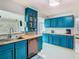 Bright kitchen featuring sleek stainless steel appliances and bold blue cabinetry with butcher block countertops at 302 E Drury Ave, Kissimmee, FL 34744