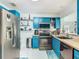 Kitchen with vibrant blue cabinets, butcher block countertops and stainless steel appliances at 302 E Drury Ave, Kissimmee, FL 34744