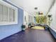 Enclosed porch featuring light-filled windows, plants, decorative ceiling fan and blue exterior at 302 E Drury Ave, Kissimmee, FL 34744
