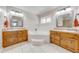 Spacious bathroom with a soaking tub, dual sinks with wood cabinets, and ceramic tile floor at 3048 Cherokee Rd, St Cloud, FL 34772
