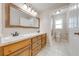 Spacious bathroom featuring double sinks, wood cabinets, and a separate toilet room at 3048 Cherokee Rd, St Cloud, FL 34772