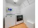 Functional laundry room featuring a washer and dryer with wire shelving for storage and light wood floor at 3048 Cherokee Rd, St Cloud, FL 34772