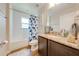 Bright bathroom with wood look floor, granite countertop, tile, and shower with patterned curtain at 3101 Drema Dr, St Cloud, FL 34769
