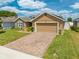 Beautiful single Gathering home featuring a brick paver driveway, tan exterior, and an attached garage at 3101 Drema Dr, St Cloud, FL 34769