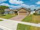 Beautiful single Gathering home featuring a brick paver driveway, tan exterior, and an attached garage at 3101 Drema Dr, St Cloud, FL 34769