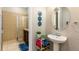 Well-lit bathroom featuring a pedestal sink, framed mirror, and glass-enclosed shower at 313 Captiva Dr, Davenport, FL 33896