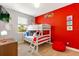 Vibrant bedroom with bunk beds, a playful design, and a colorful red wall at 313 Captiva Dr, Davenport, FL 33896