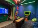 Colorful game room featuring shuffleboard table, comfortable seating, and entertainment system at 313 Captiva Dr, Davenport, FL 33896