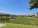 A tranquil pond view surrounded by townhomes and lush greenery on a clear, sunny day at 313 Captiva Dr, Davenport, FL 33896
