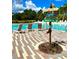 Community pool with unique directional sign, brick pavers, and lounge chairs, perfect for relaxing at 313 Captiva Dr, Davenport, FL 33896