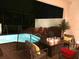 Outdoor pool area with a fire table, patio seating, mature landscaping, and -safe fence at 313 Captiva Dr, Davenport, FL 33896