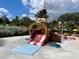 Community pool with a pirate ship water slide, surrounded by lush landscaping and tropical foliage at 313 Captiva Dr, Davenport, FL 33896