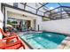 Inviting pool area with a screened lanai, comfortable seating, and a convenient grill at 313 Captiva Dr, Davenport, FL 33896