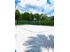 Outdoor sand volleyball court with net surrounded by lush green trees under partly cloudy skies at 313 Captiva Dr, Davenport, FL 33896